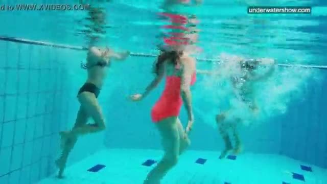 Three nude girls have fun underwater